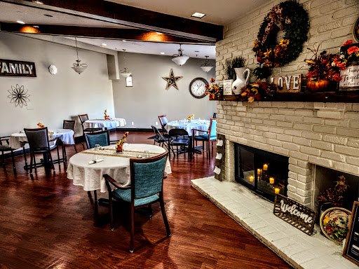 A cozy dining space with festive decorations and a warm fireplace.