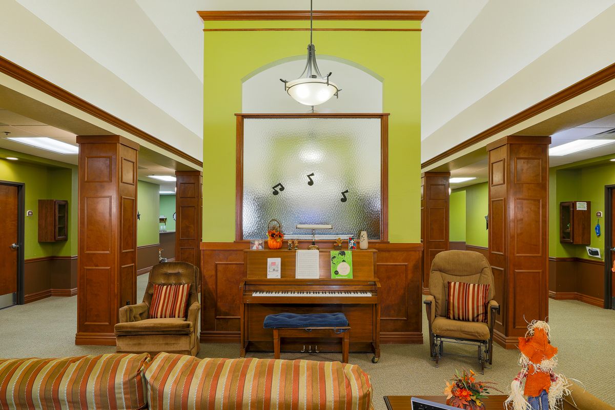 A cozy lounge with a piano and comfortable seating in a warmly decorated room.