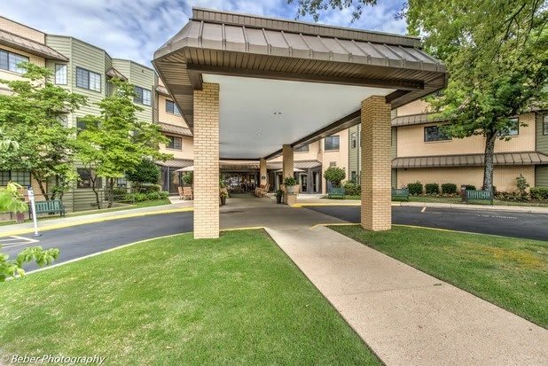 Covered entrance with a canopy leading to a building, surrounded by well-maintained landscaping.