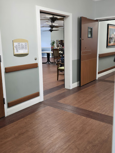 A view of a well-lit hallway in a healthcare facility, showcasing doors and an inviting atmosphere.