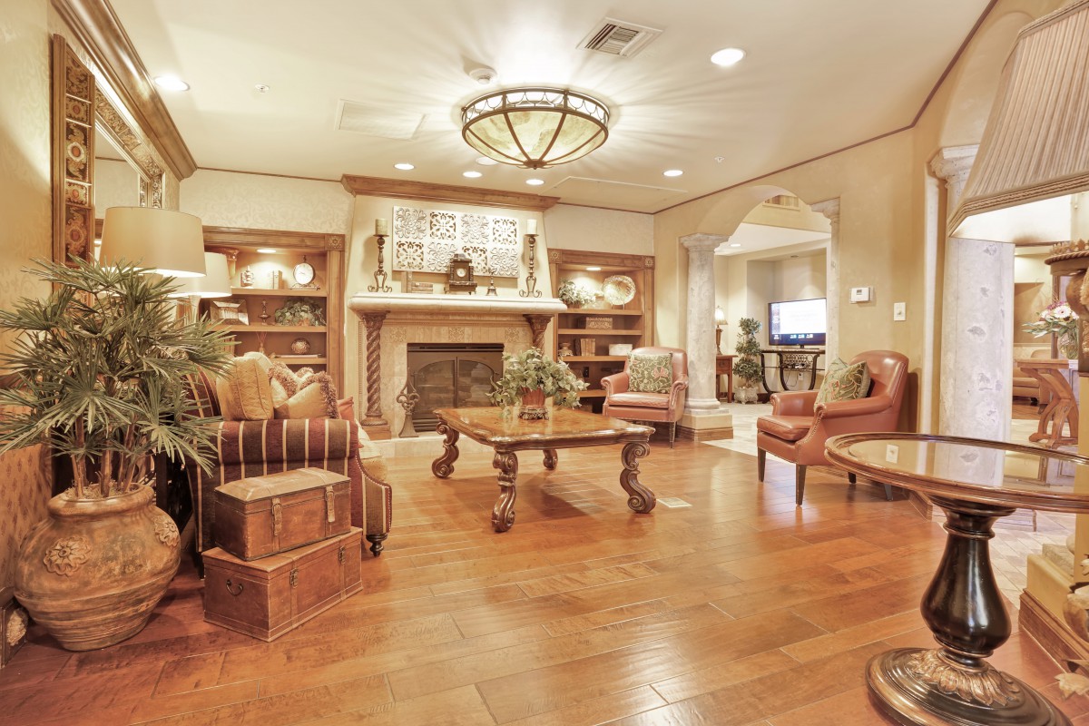 A warmly decorated living room featuring a fireplace, wood flooring, and traditional furnishings.