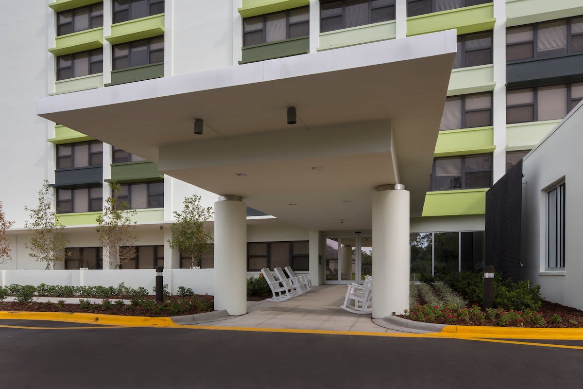The entrance of a modern building with a canopy and large columns.