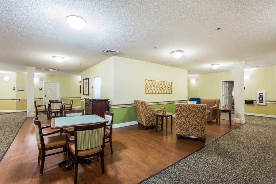 A cozy room with tables and chairs, well-lit with warm decor.