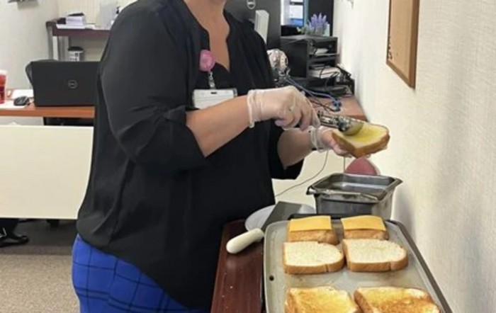 A person preparing cheese sandwiches in a kitchen setting.