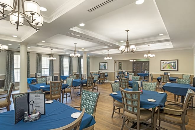 A well-lit dining area with blue tablecloths and elegant decor.