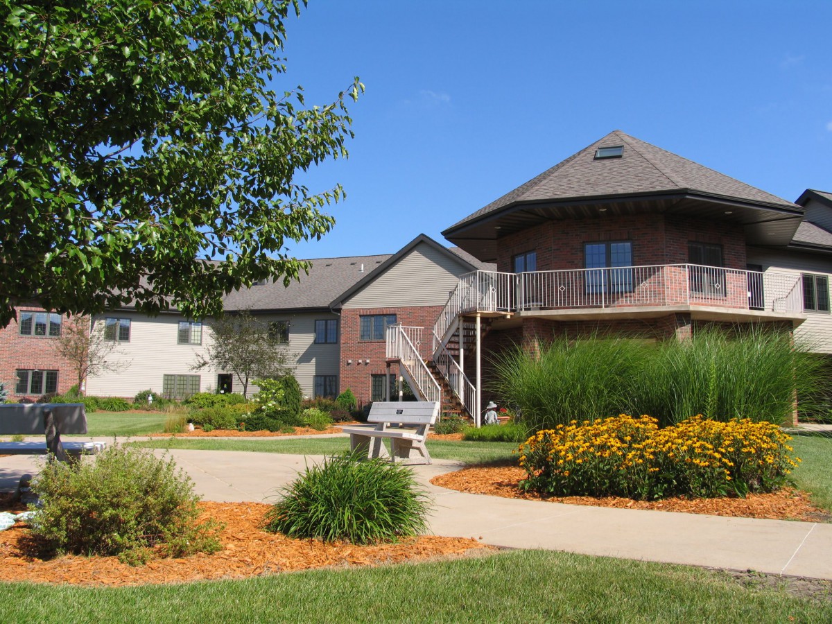 A residential building with well-maintained landscaping and a driveway.