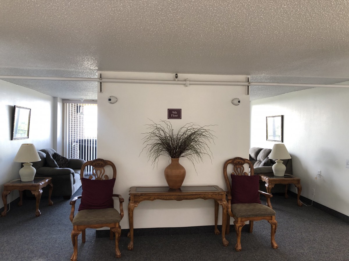 A cozy living room area with two chairs and a table featuring a decorative vase.