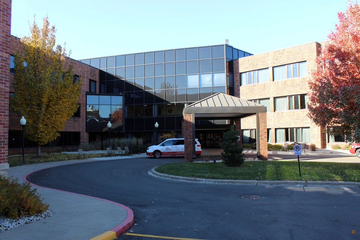 A modern hospital building with a main entrance and large glass windows.