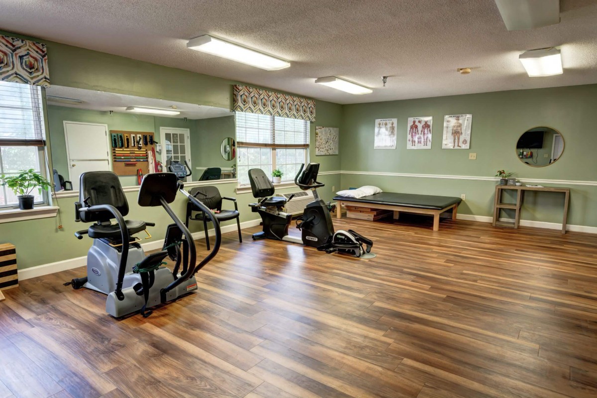 A clean and spacious gym with stationary bikes and a workout bench for fitness training.