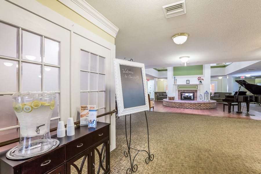 A cozy lobby area with a fireplace and a sign on an easel.