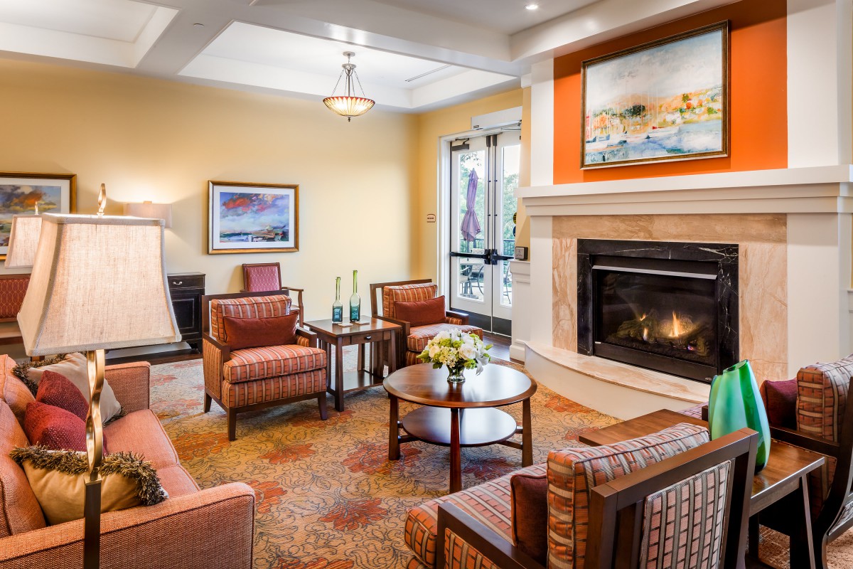 A cozy living room with a fireplace, comfortable seating, and warm decor.