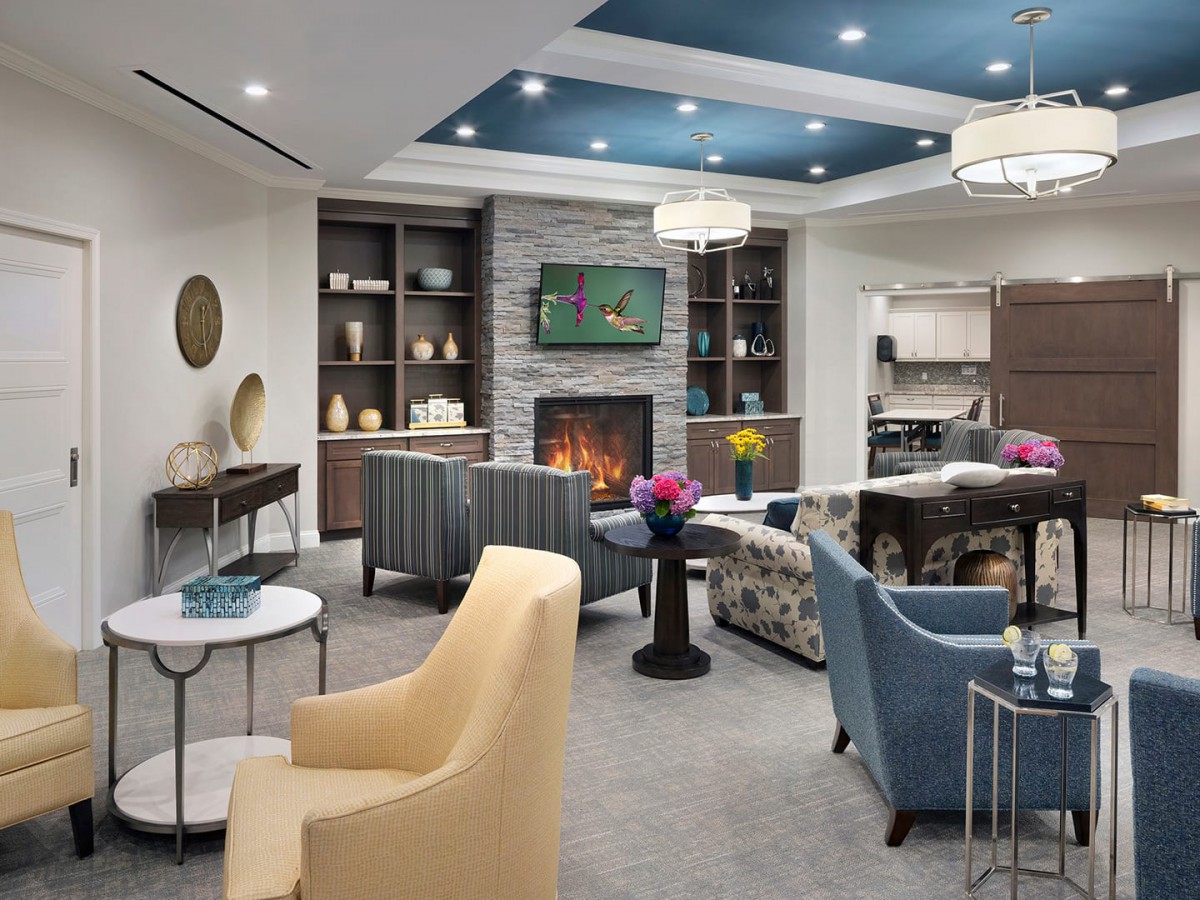 A modern and cozy living room with a central fireplace, various seating options, and stylish decor.