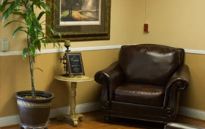 A cozy corner with a leather armchair, small table, and decorative elements.