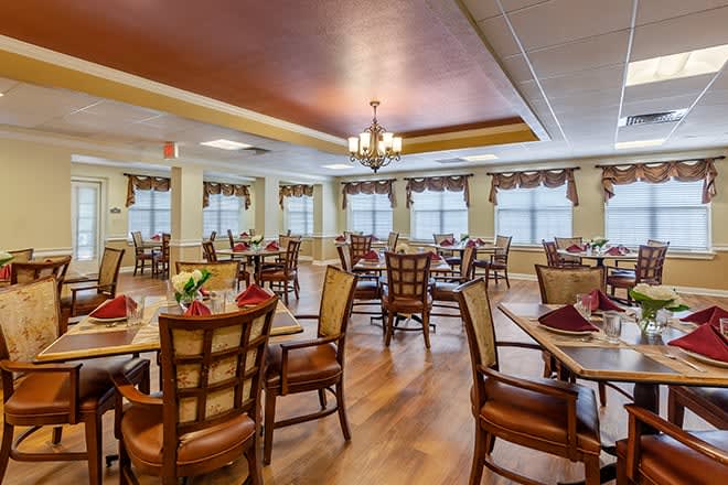 A well-decorated dining room with multiple tables and chairs arranged elegantly.
