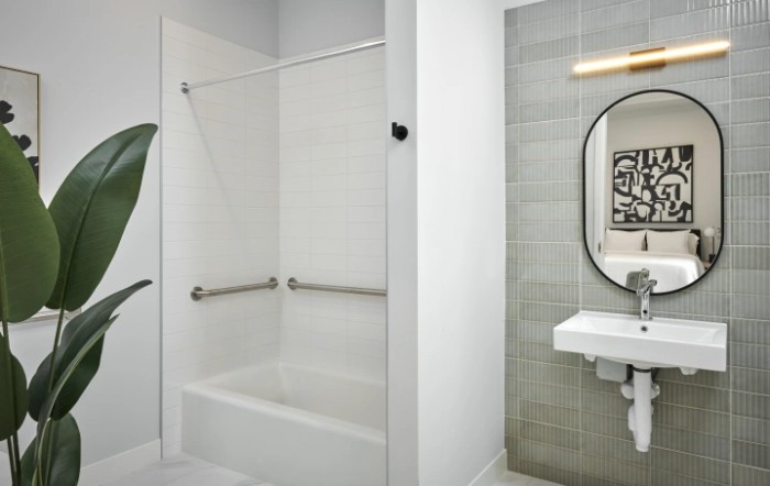 A modern and clean bathroom with a shower, bathtub, and sink area.