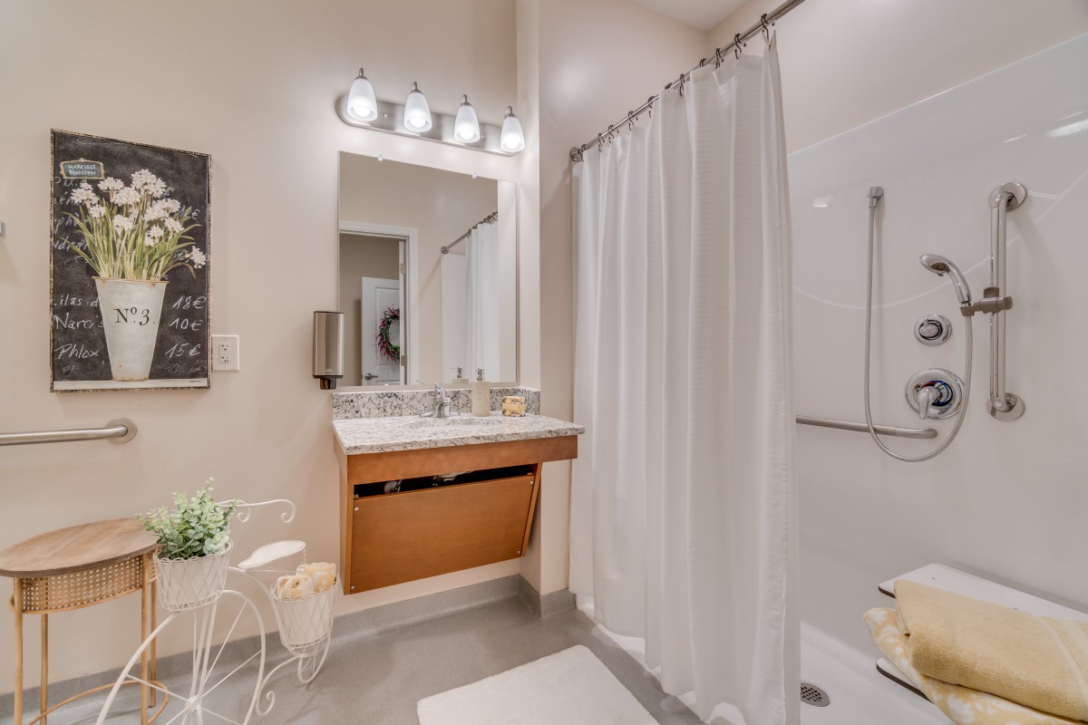A modern bathroom with a minimalist design, featuring a vanity, mirror, and shower curtain.