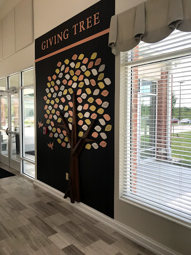 A vibrant wall art featuring a giving tree with colorful leaves, symbolizing generosity and community spirit.