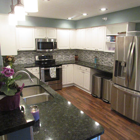 Modern kitchen with stainless steel appliances and granite countertops.