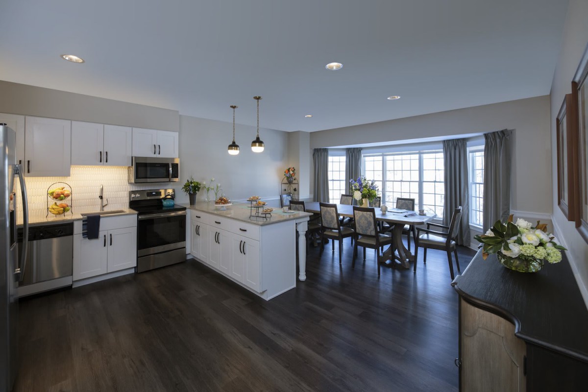 A modern open-concept kitchen and dining area with hardwood floors and stylish lighting.