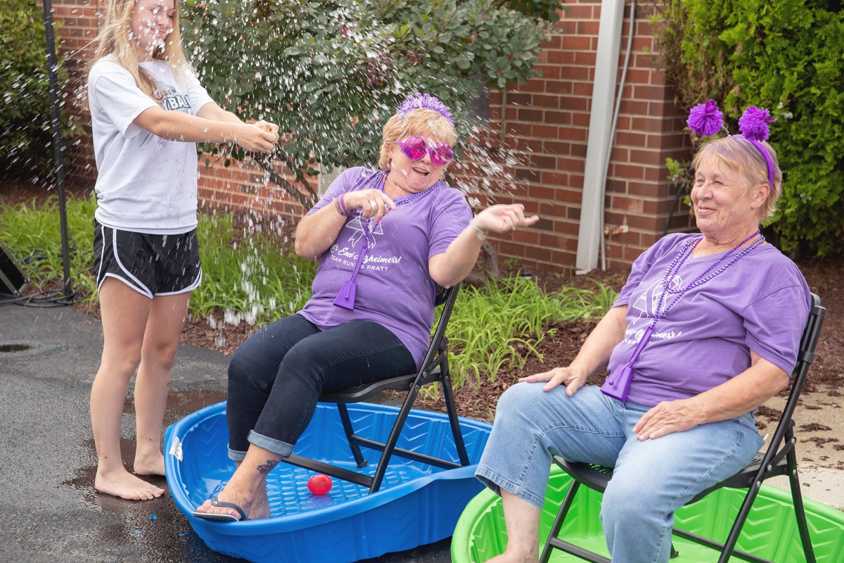 A group of people enjoying a playful outdoor gathering with kiddie pools.