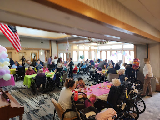 A lively gathering at a community center filled with elderly individuals enjoying an event together.