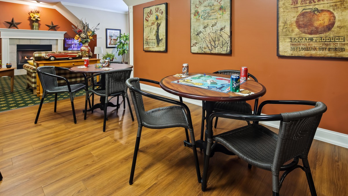 A cozy game room with tables set up for board games and decorated walls.