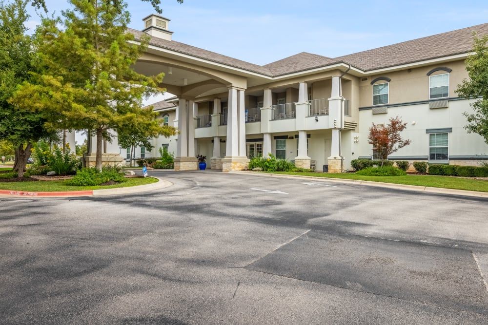 A large building with prominent columns at the entrance and a spacious parking lot.