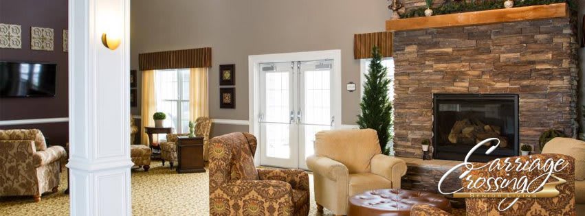 A cozy living room featuring patterned and plain armchairs with bright windows and elegant curtains.