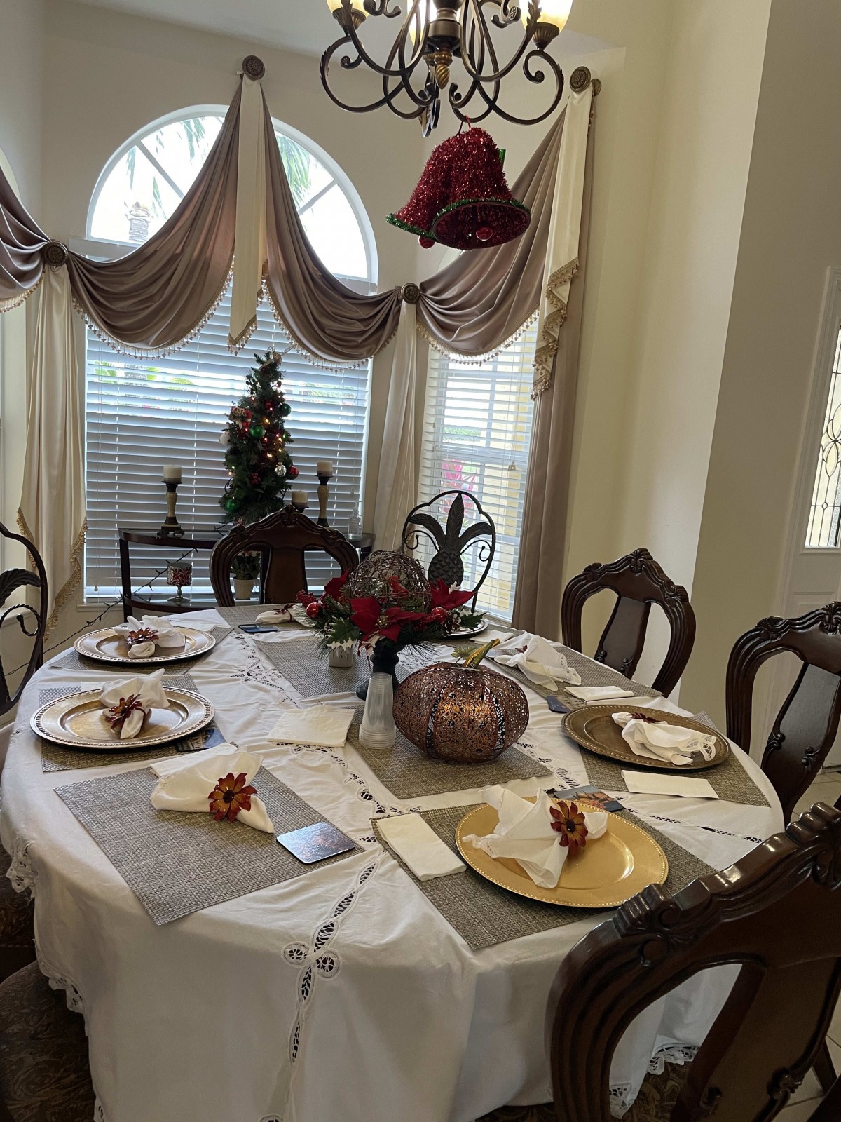 A beautifully decorated dining table prepared for a festive gathering, featuring elegant place settings and holiday decorations.