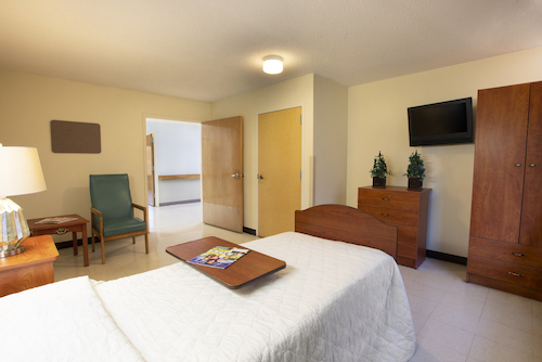 A cozy and well-furnished bedroom with a comfortable bed, seating area, and modern amenities.