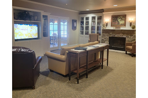 A cozy living room with comfortable seating and a warm atmosphere, featuring a television and a fireplace.