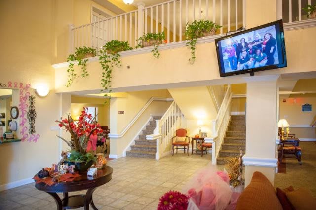 A welcoming lobby area featuring a staircase, decorative plants, and comfortable seating.