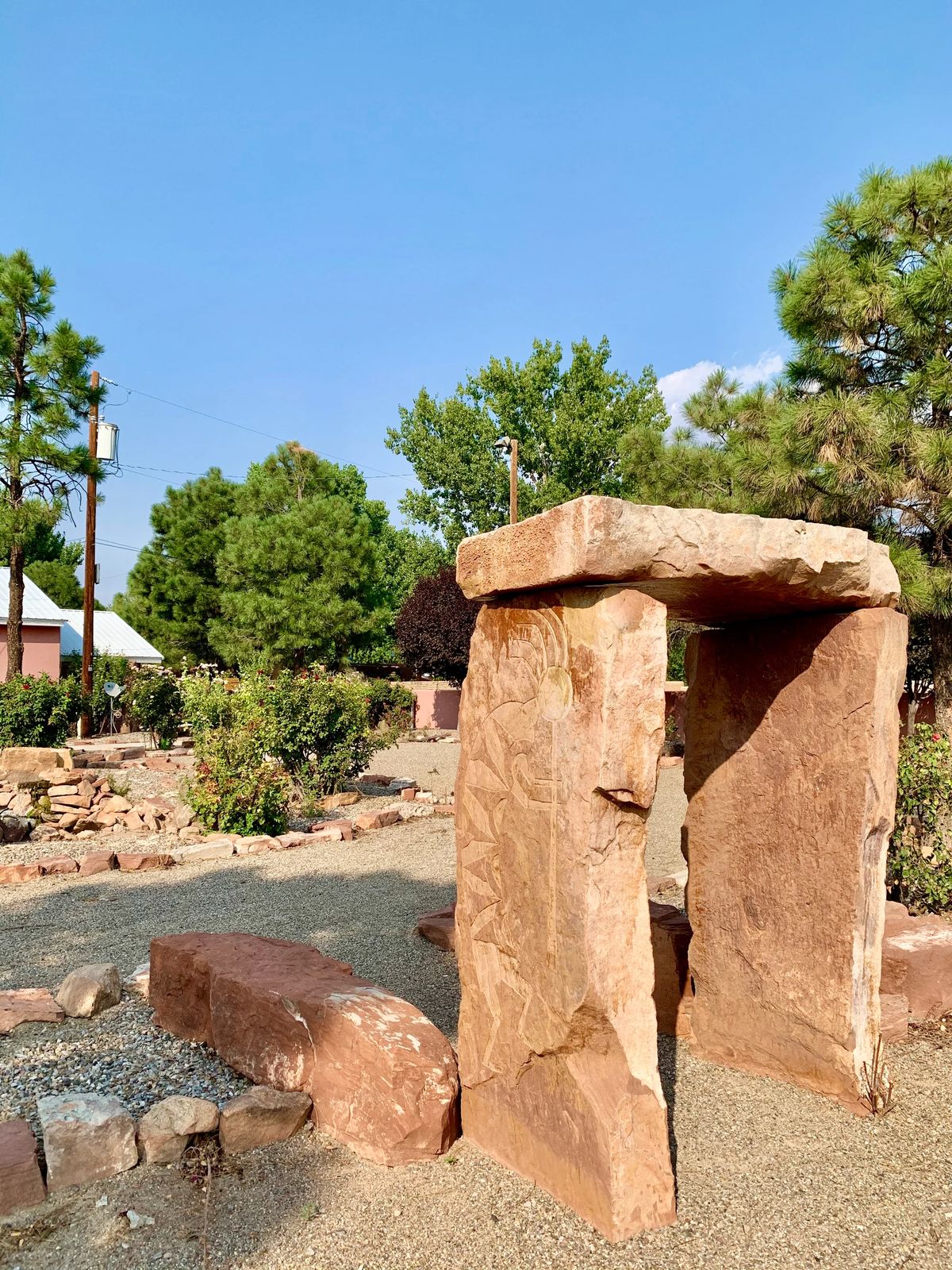 A stone structure set in a landscaped garden with trees and greenery.