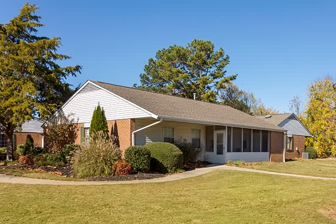 A suburban single-story brick house with a well-maintained yard.