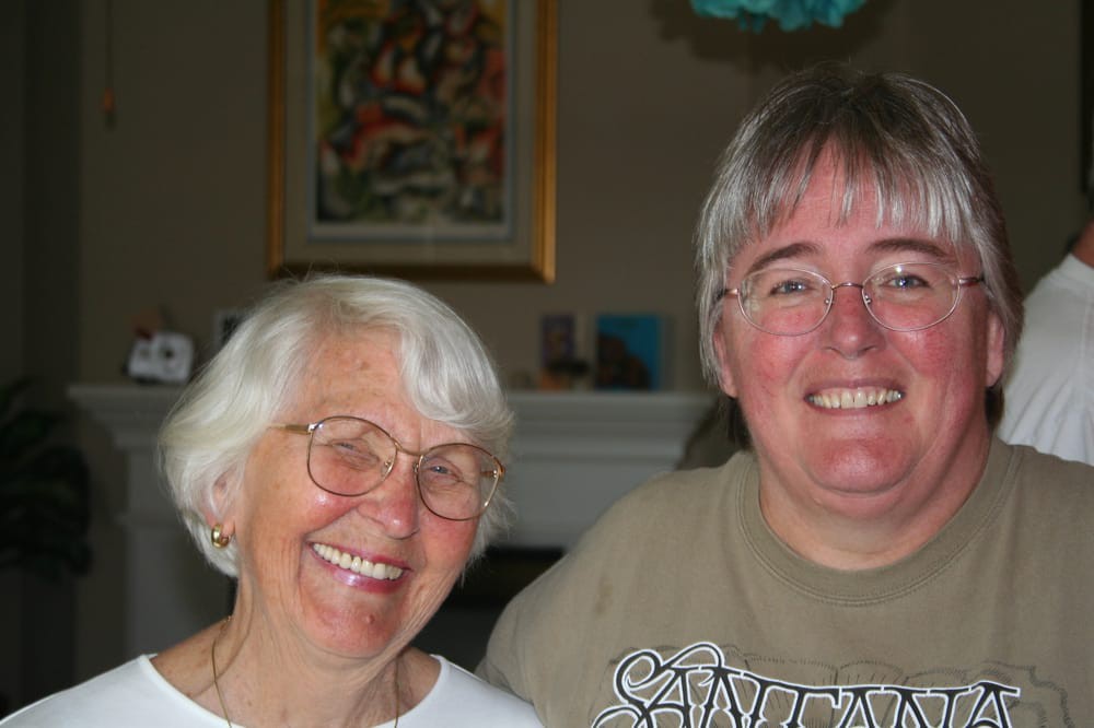 Two people smiling indoors.