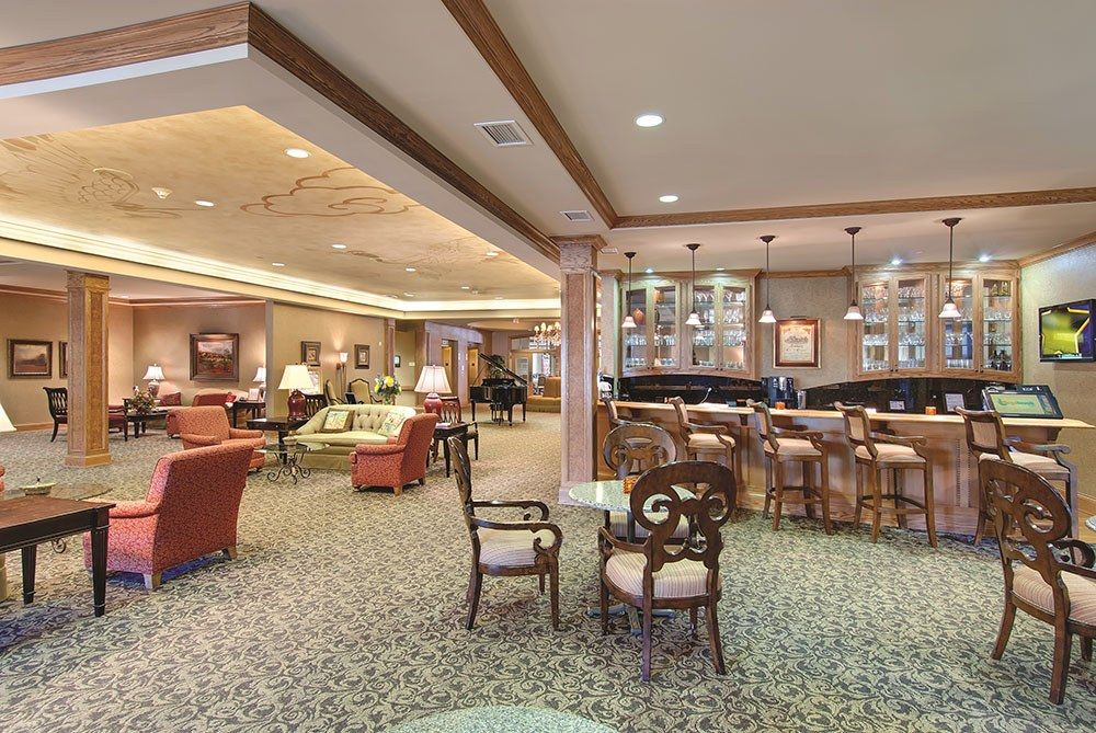 A cozy lounge with seating and a bar area, featuring comfortable furniture and warm lighting.