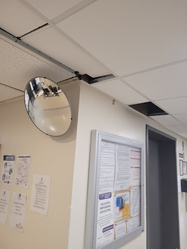 A convex mirror mounted on the ceiling, reflecting part of the room.
