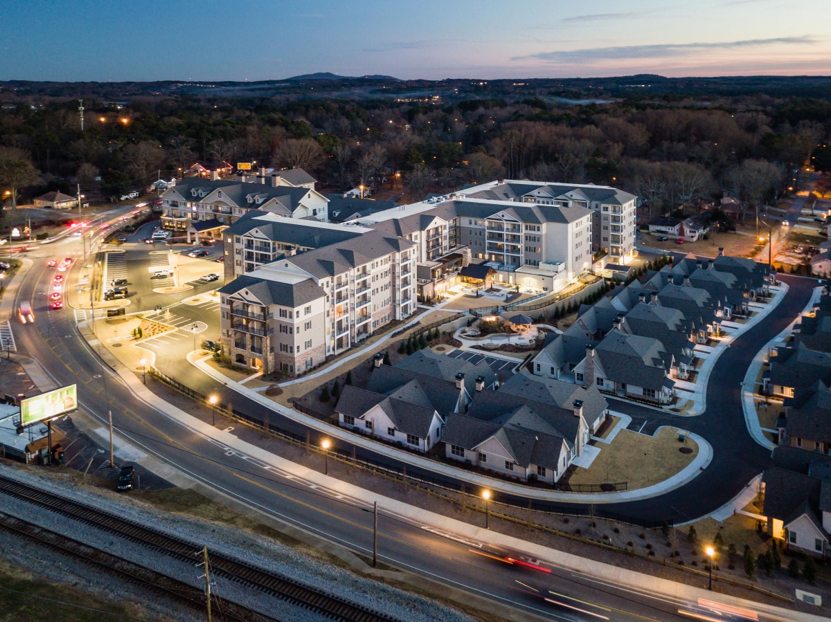 Aerial view of a residential apartment complex illuminated in the evening.