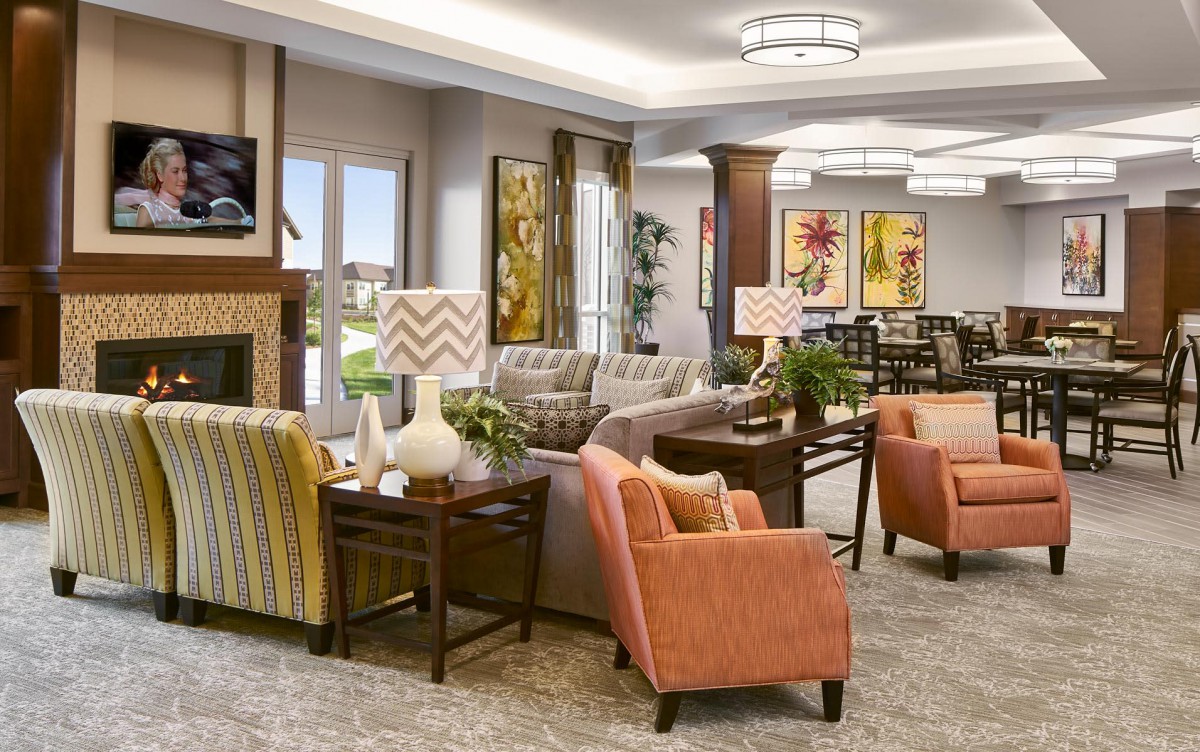 A cozy and well-decorated living room with a variety of seating options, including sofas and armchairs, complemented by stylish lamps and artwork.