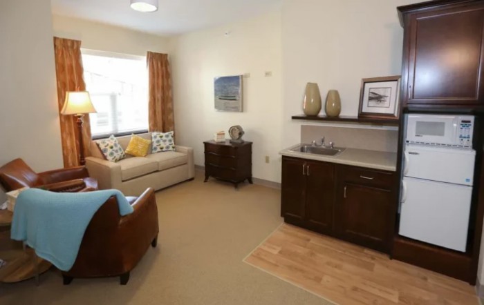 A cozy living room with a sofa, armchair, side table, and decor items.