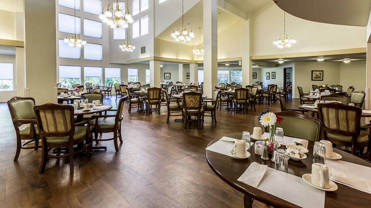 Spacious and elegantly decorated dining room with large windows and ample seating.