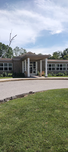 A modern school building with a welcoming entrance surrounded by greenery.