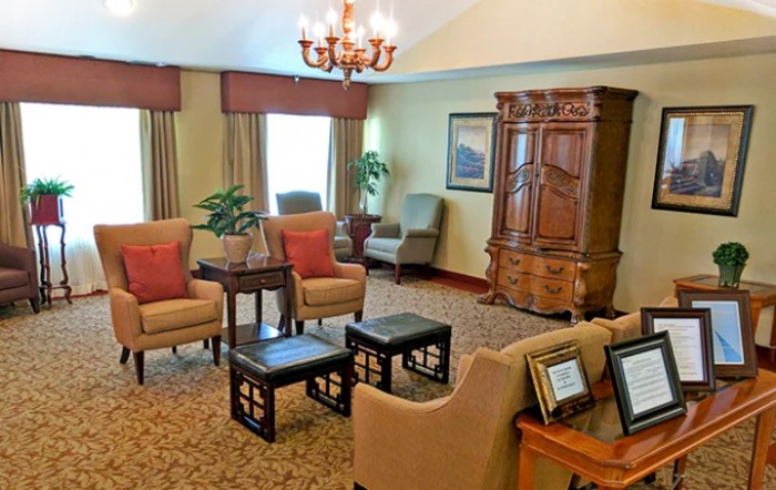A cozy living room with comfortable armchairs, a wooden cabinet, and elegant decor.