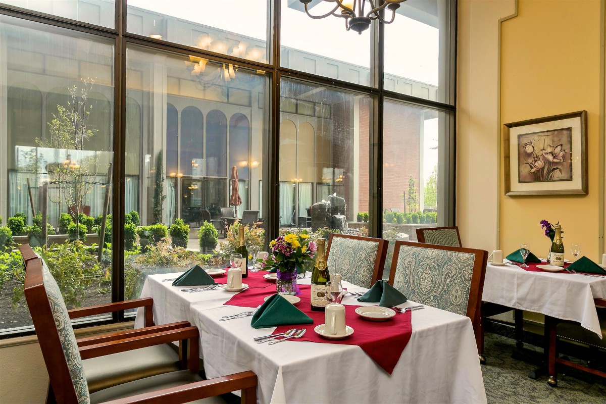 A beautifully set dining table near large windows in a restaurant.