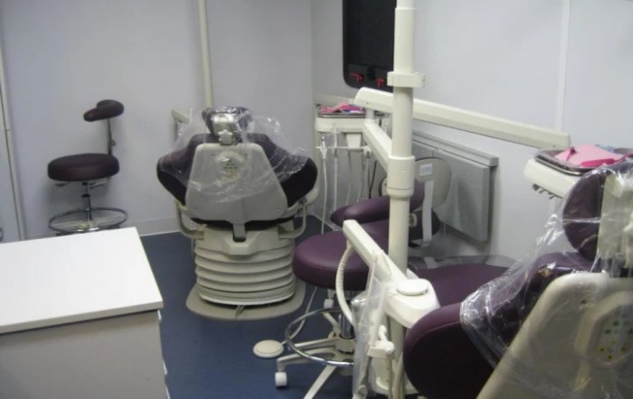 A dental office with a dentist chair and medical equipment.