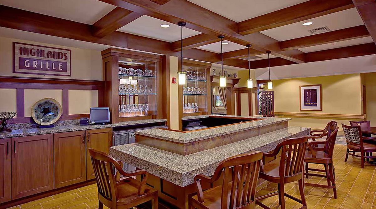 A cozy bar area with wooden furniture and ample lighting.