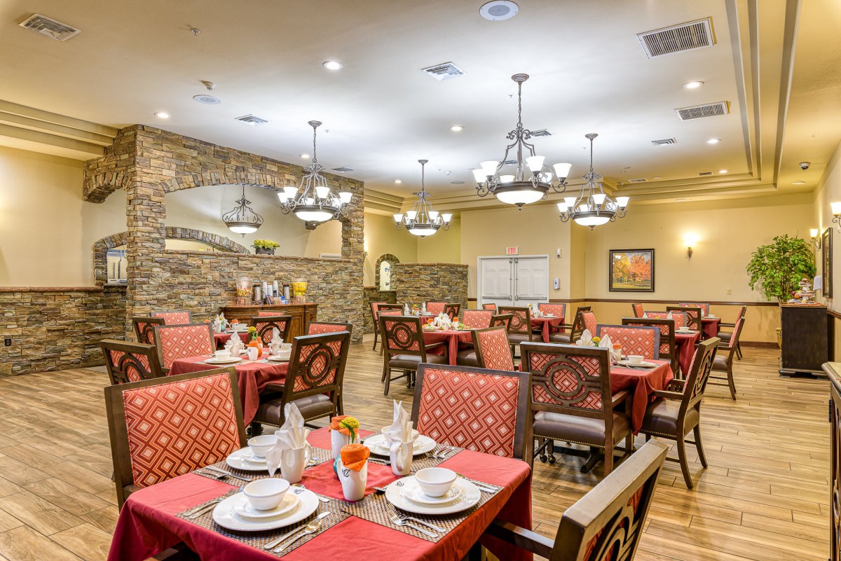 A cozy restaurant dining area with neatly arranged tables and elegant chandeliers.