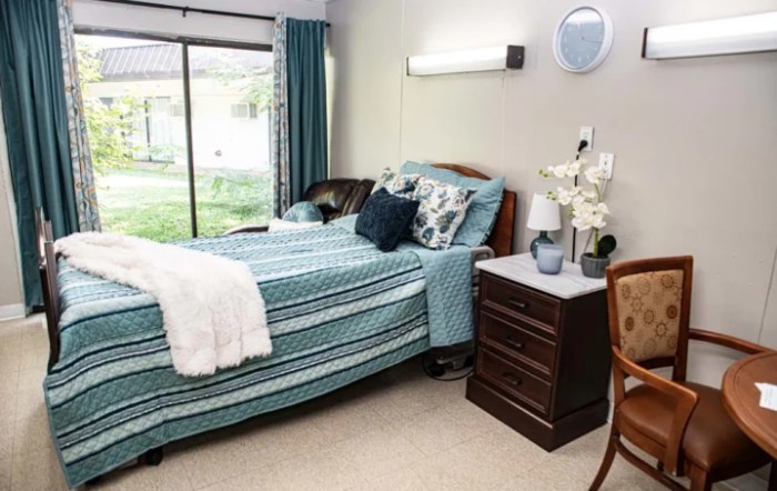 A well-decorated bedroom with a striped bedspread and a nightstand.