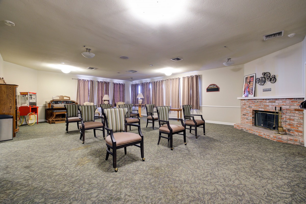 An empty meeting room with several chairs arranged in rows on a carpeted floor.