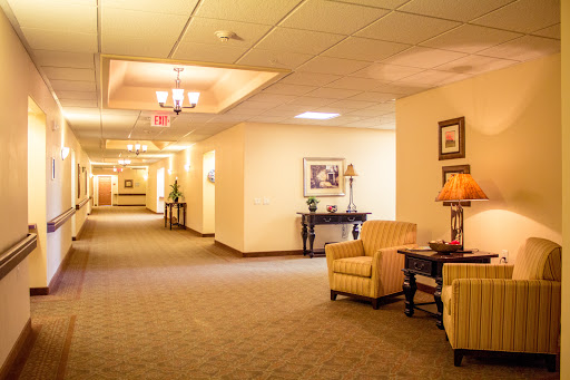 A well-lit hallway featuring comfortable seating and decorative elements, creating a welcoming atmosphere.